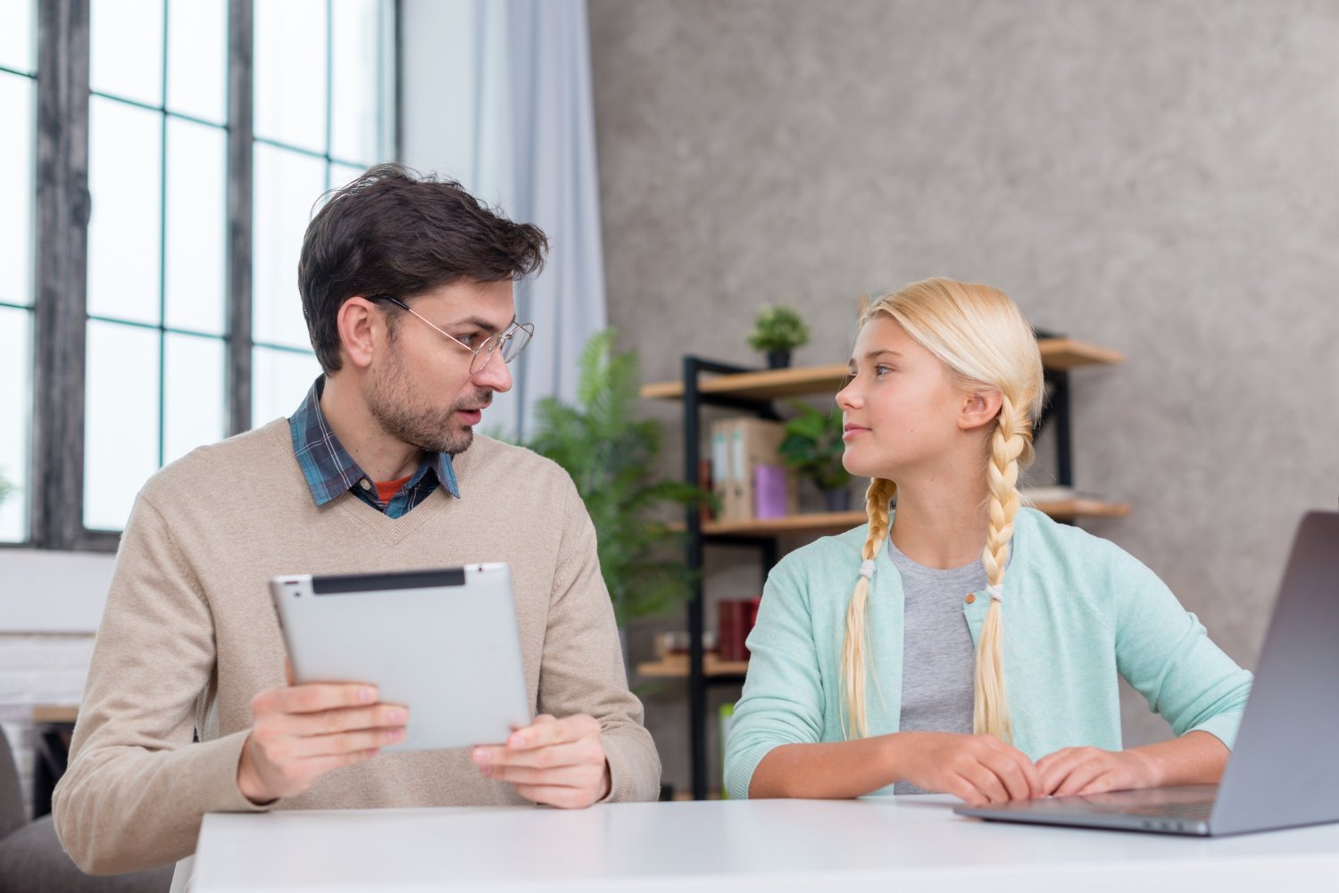 Two people speaking together in a bright community workspace.