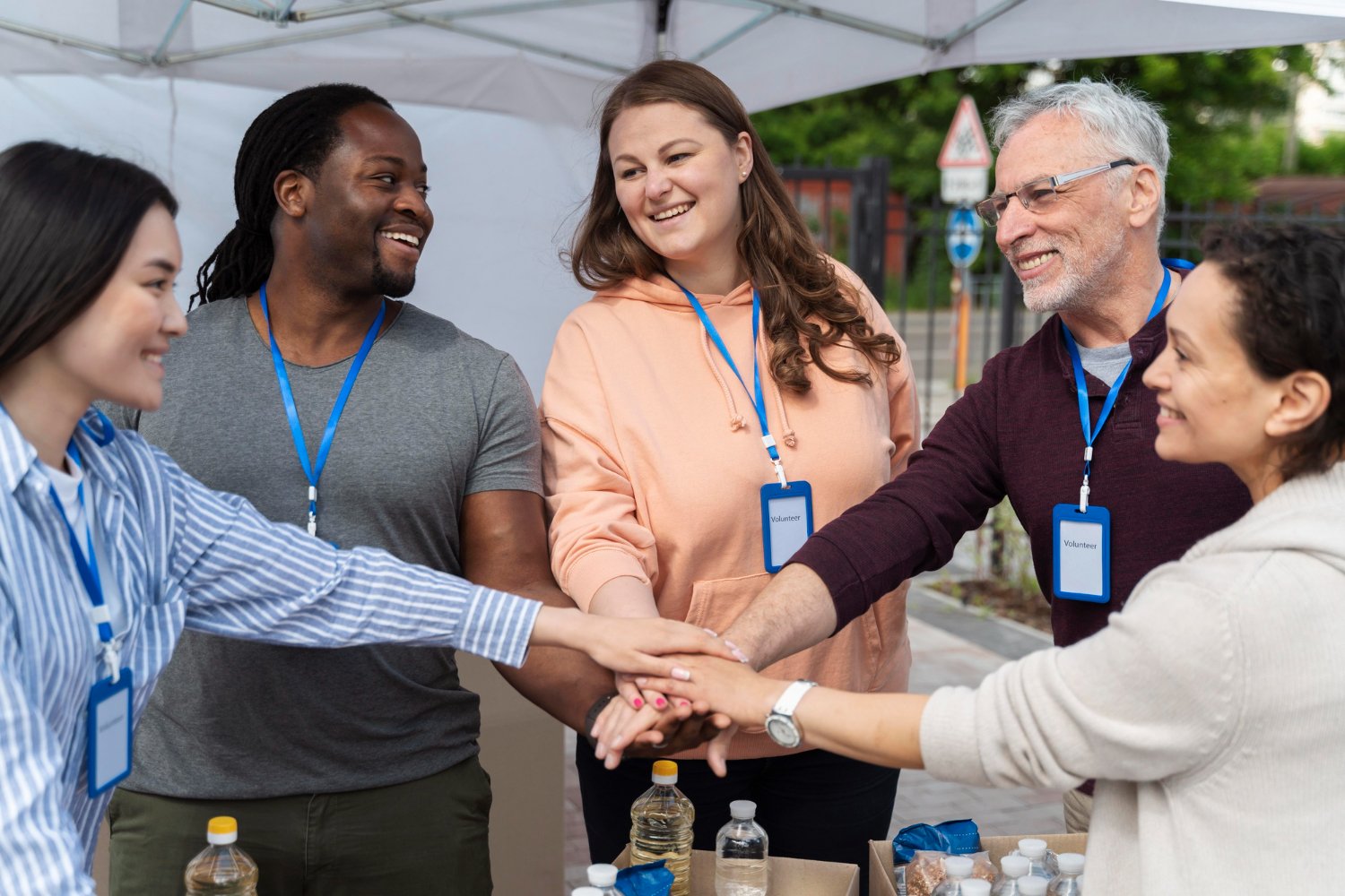 A diverse group of volunteers sharing a moment of connection outdoors.